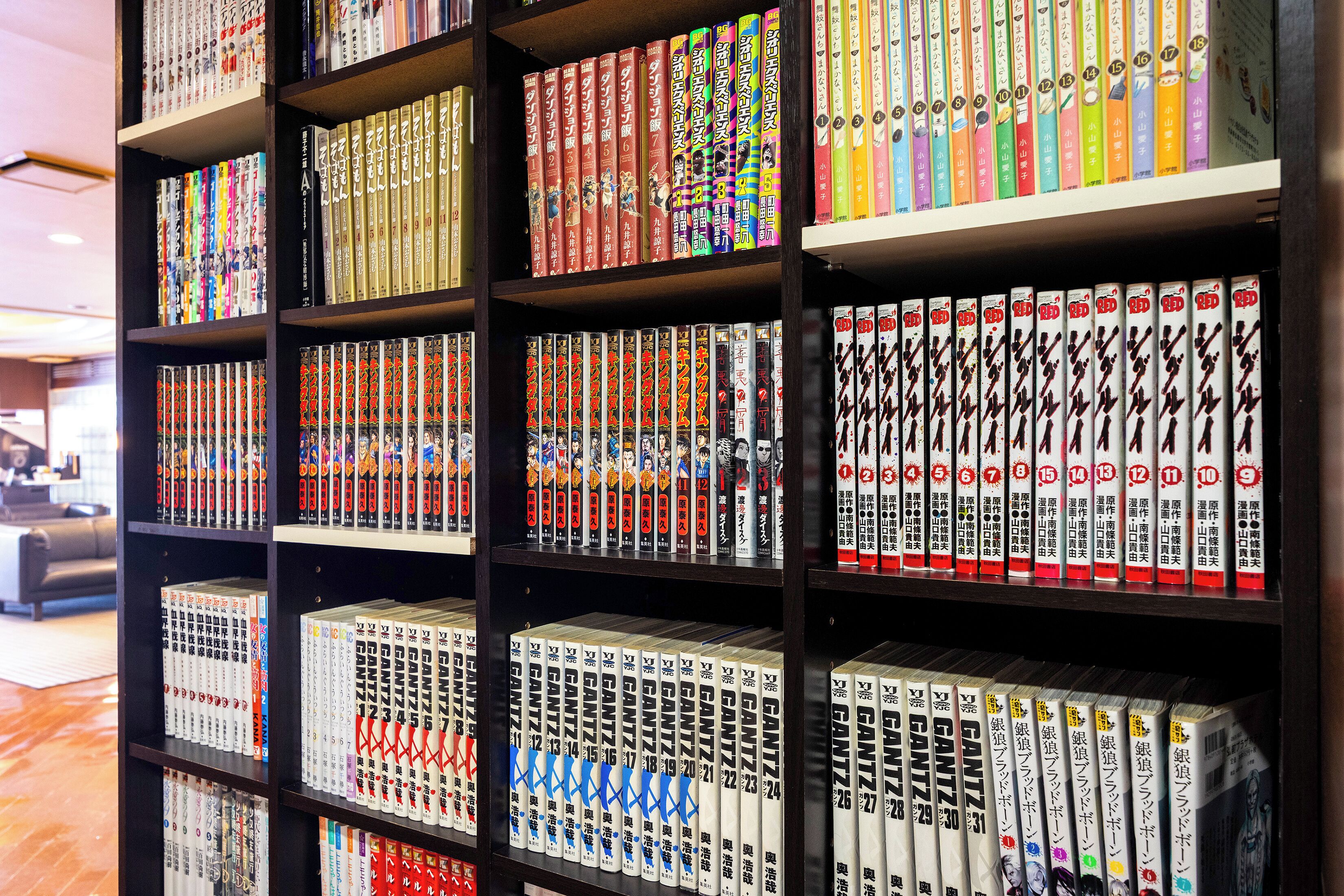 Uma estante cheia de livros diversos, alguns com capas coloridas e outros com designs simples.