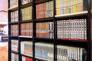 Een boekenplank vol met boeken, sommige met kleurrijke omslagen en andere met eenvoudige designs.