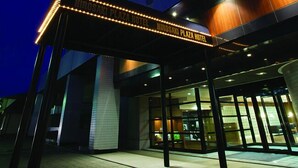 La façade de l’hôtel Hiroaki Plaza, avec son enseigne lumineuse et son entrée moderne.