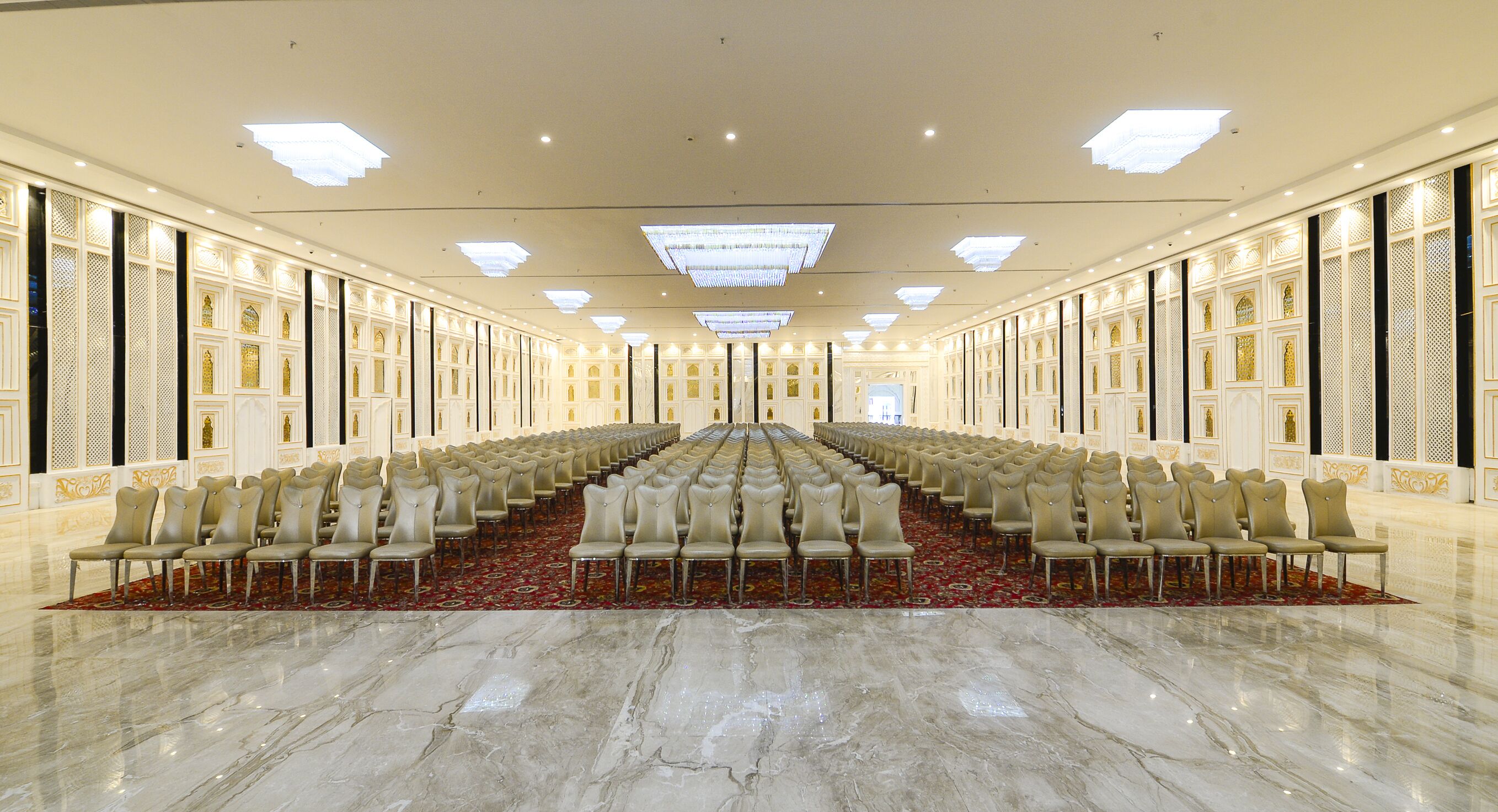 A large, well-lit conference room with rows of chairs and a polished marble floor.