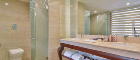A bathroom with a glass shower enclosure, a wooden vanity with a mirror, and a towel rack.