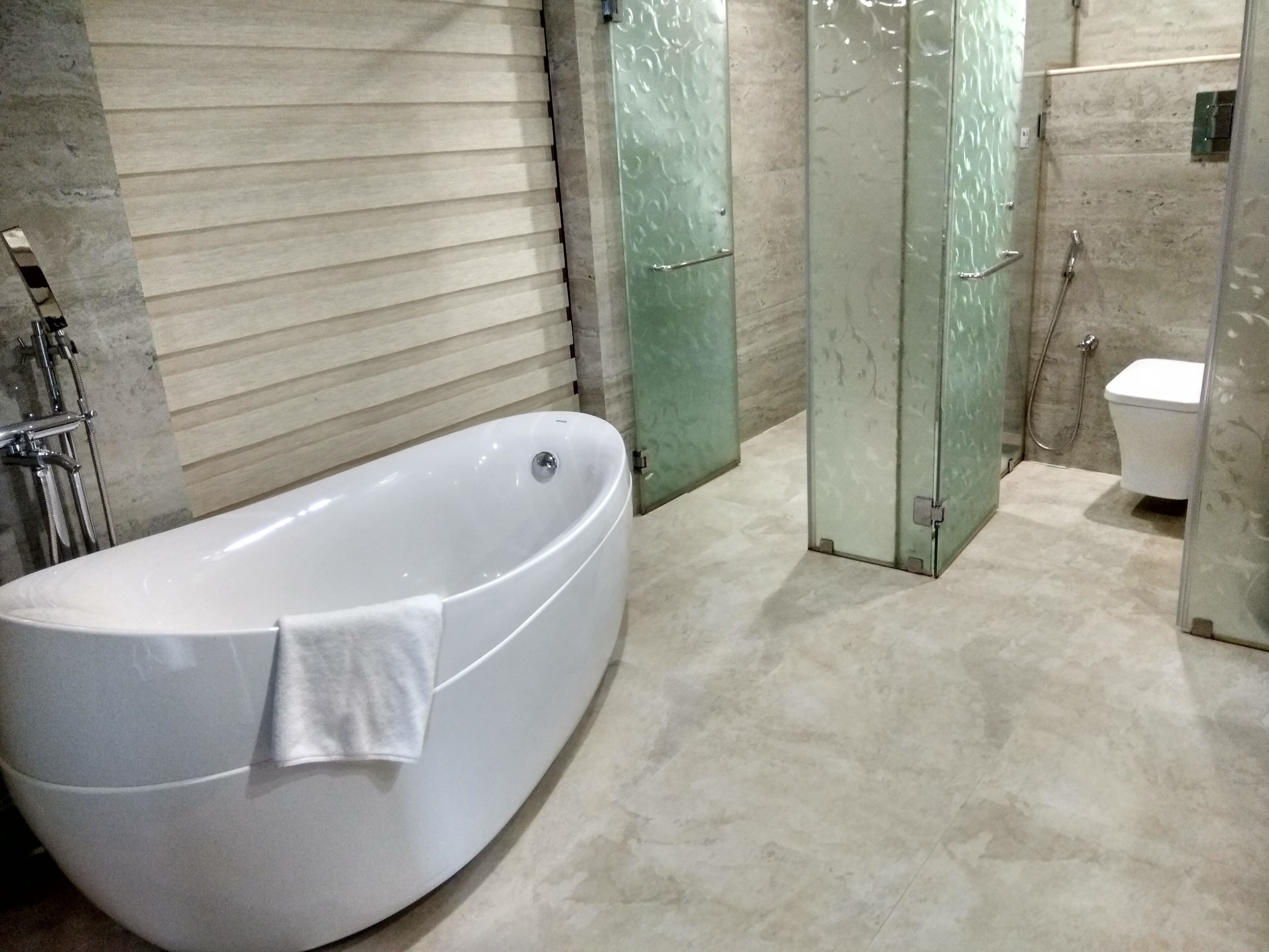 Un baño moderno con una bañera independiente, cabina de ducha con mampara de vidrio y un inodoro.