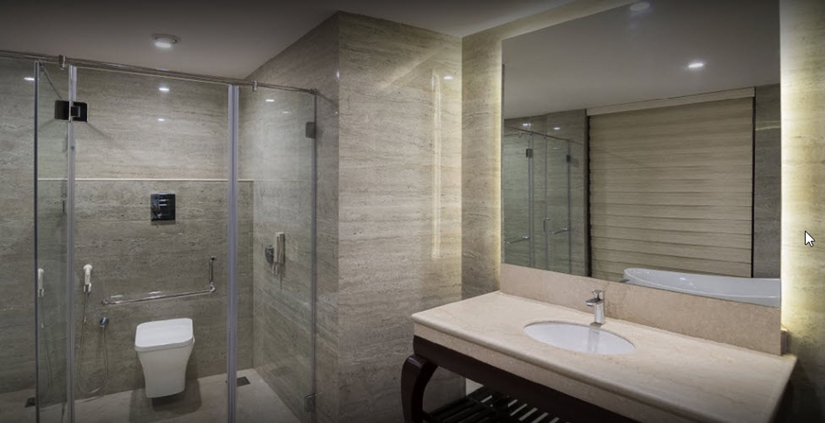 Ein modernes Badezimmer mit einer Duschkabine, einer weißen Toilette und einem Waschtisch.