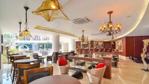 A spacious lobby with a curved ceiling, multiple seating areas, and a variety of lighting fixtures. - Park Regis Goa (Arpora)