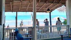 Un espacio de estar al aire libre cubierto con vistas a la playa.