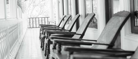 A row of wooden benches under a covered area with arched windows.