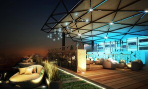 A modern outdoor lounge area with seating and a bar.