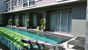 Una piscina al aire libre, sombrillas, tumbonas