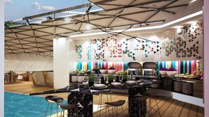 Cocina moderna con barra junto a la piscina, destacando diseños geométricos en las paredes y una amplia variedad de exhibiciones de comida y bebidas.