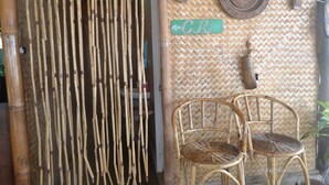 A bamboo fence, two wicker chairs, and a woven wall with a 'CR' sign. - Floresita's Beach Resort (El Nido)