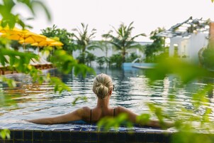 Una piscina al aire libre, sombrillas, tumbonas