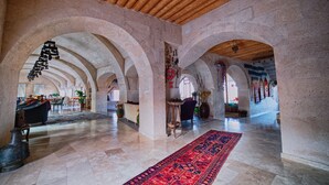 An interior with arched ceilings, a red carpet, and a stone wall. - Kistar Cave Hotel (Nevsehir)