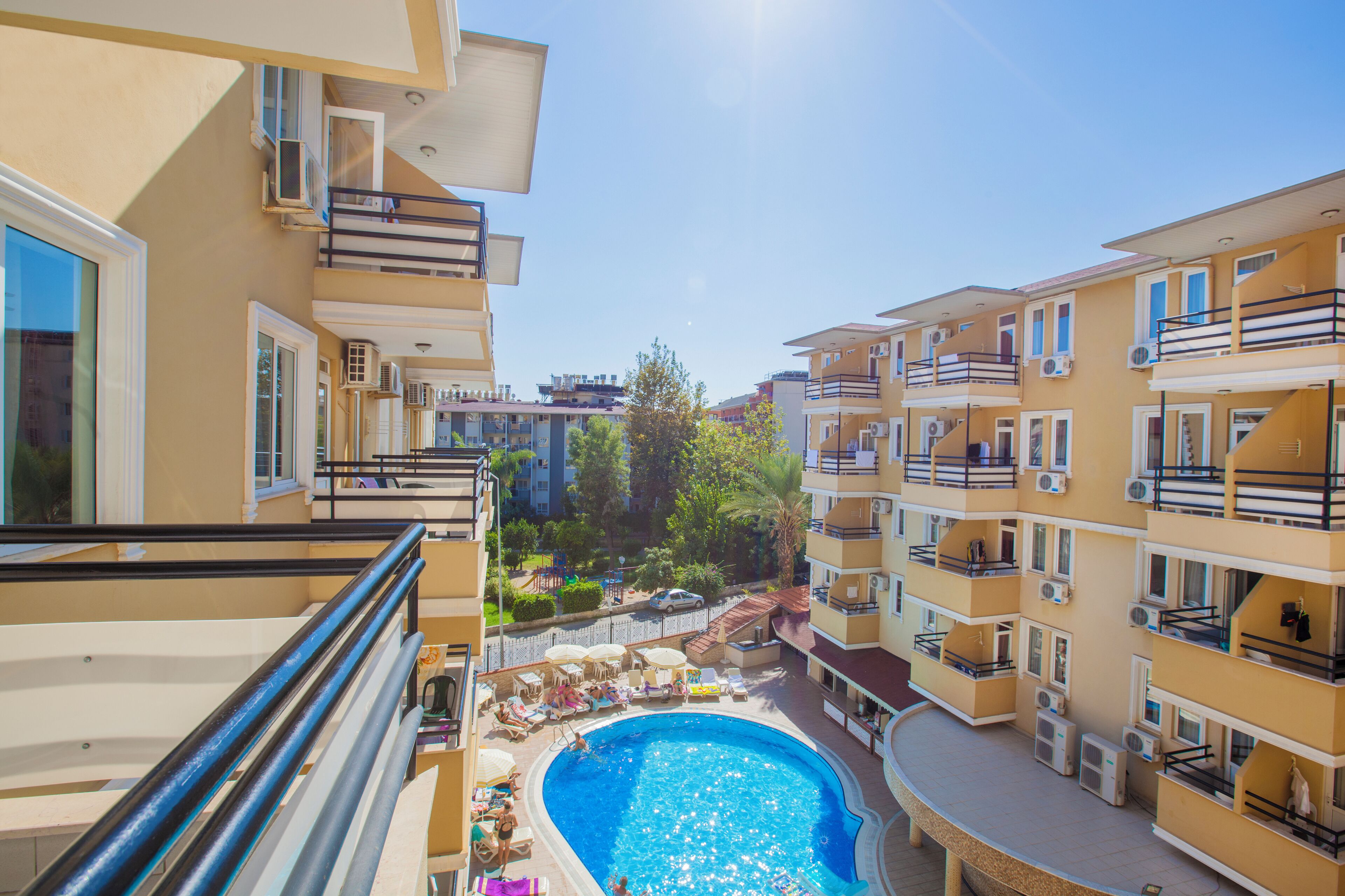 A residential building with a swimming pool, balconies, and air conditioning units.
