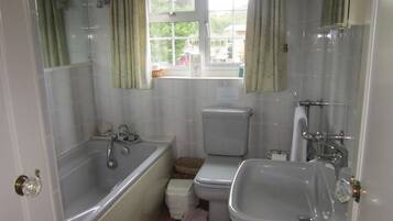 Un baño con bañera, inodoro y lavabo.