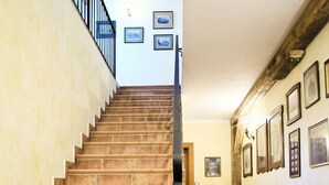 A staircase with a handrail, leading to a landing with framed pictures on the wall. - Apartmány U Zvonu (Cesky Krumlov)