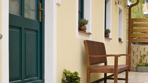 A house with a green door, a bench, and potted plants. - Apartmány U Zvonu (Cesky Krumlov)