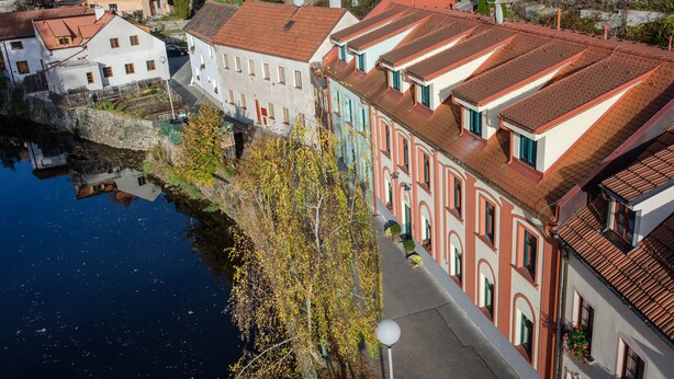 A riverside town with historic buildings, a bridge, and a canal. - Apartmány U Zvonu (Cesky Krumlov)