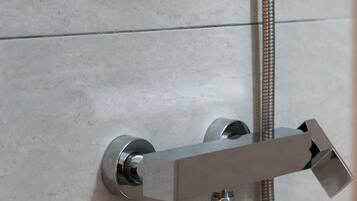 A modern shower with a glass enclosure and a handheld showerhead.