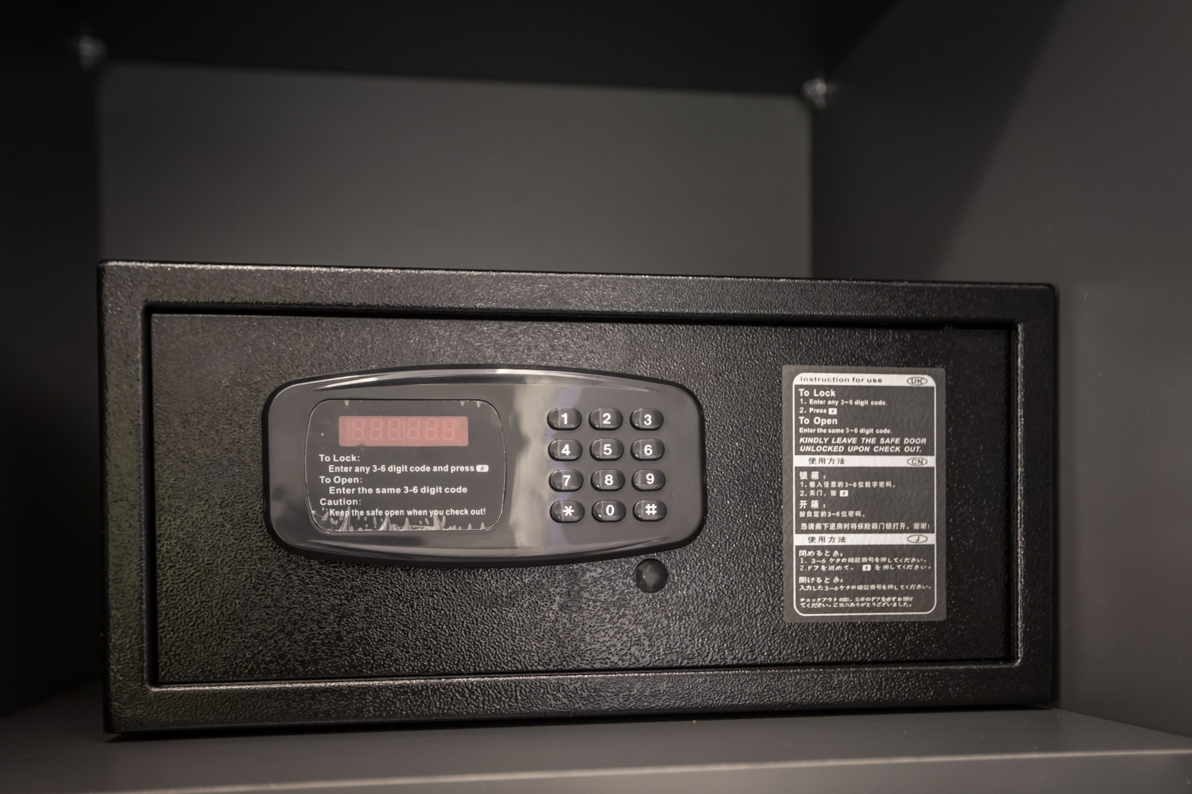 Una caja fuerte con teclado digital e instrucciones de uso.