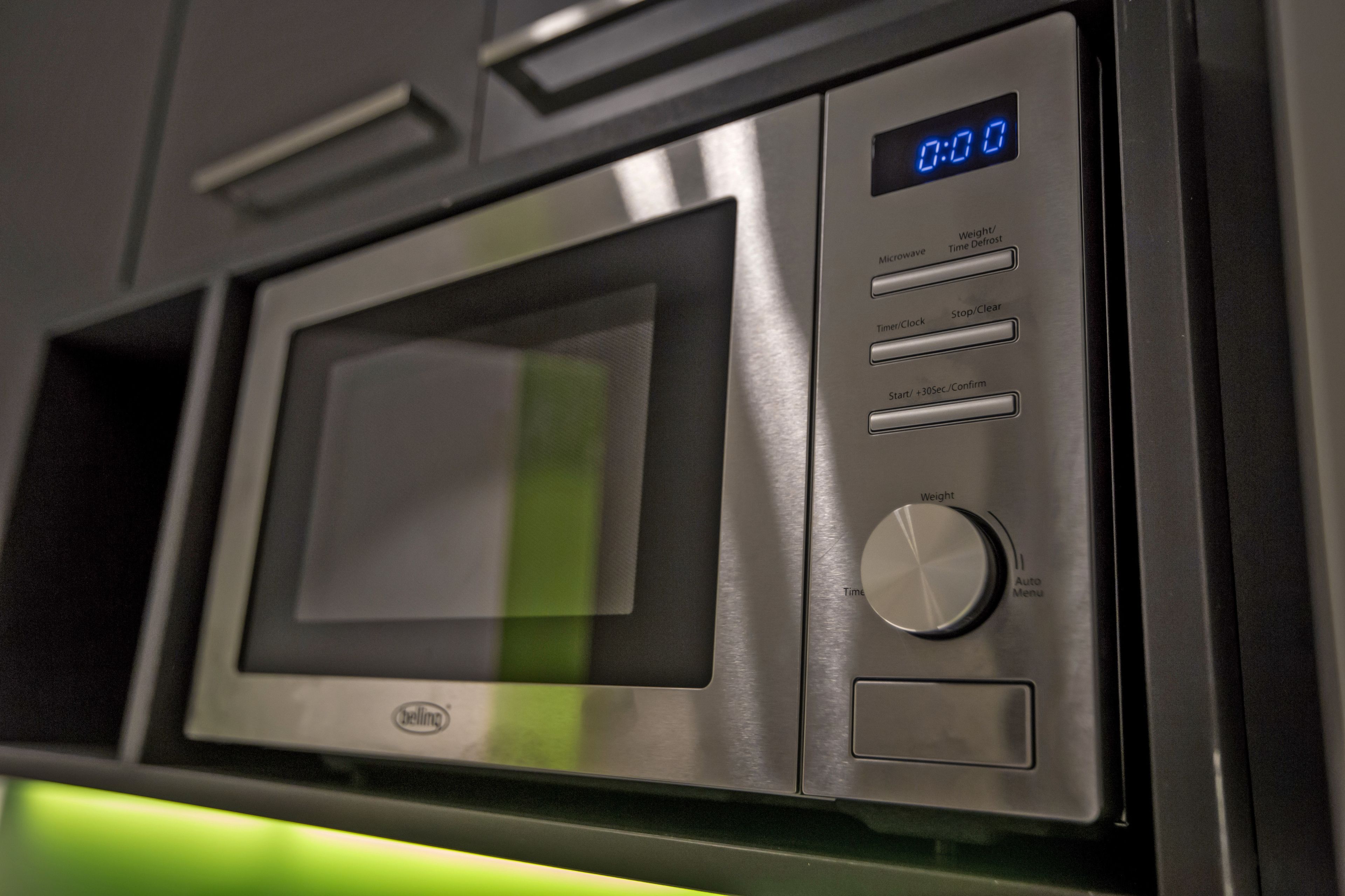 Un horno microondas con pantalla digital, botones de control y el logotipo de la marca.