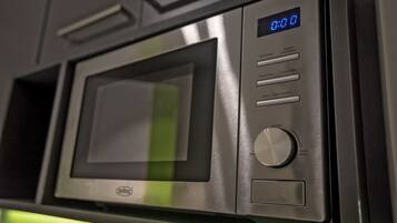 Un horno microondas con pantalla digital, botones de control y el logotipo de la marca.