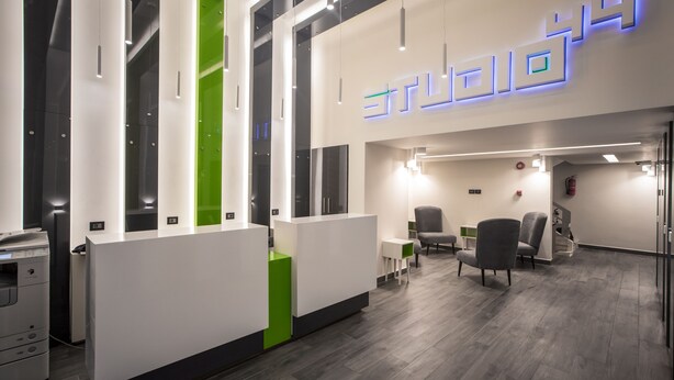 A modern reception area with a reception desk, seating, and a visible fire extinguisher.