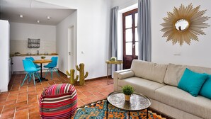 Un salon comprenant un canapé, une table basse et un coin repas avec des chaises et une table.