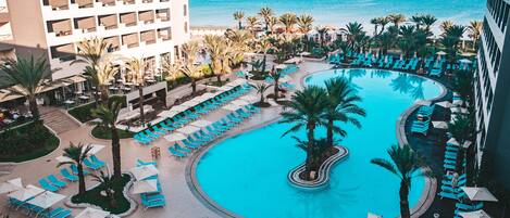 Piscine couverte, piscine extérieure, parasols de plage, chaises longues