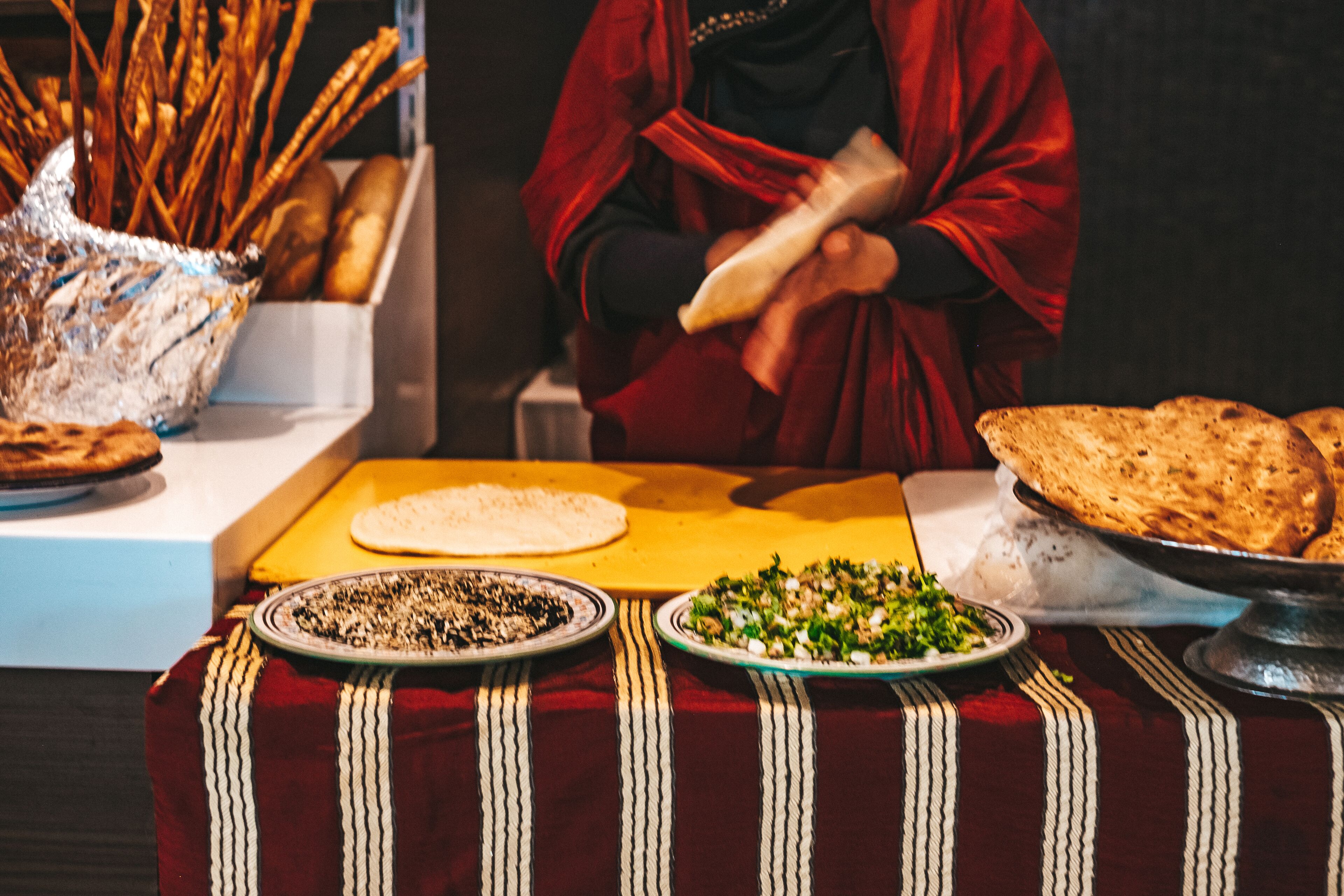 A table with various food items including bread, a salad, and a plate with what appears to be a dessert or pastry.