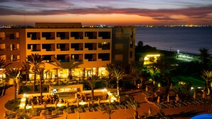 Un hotel con varios pisos, piscina al aire libre y acceso a la playa.