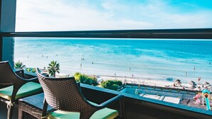 Un balcón con sillones de mimbre y vista a la playa.