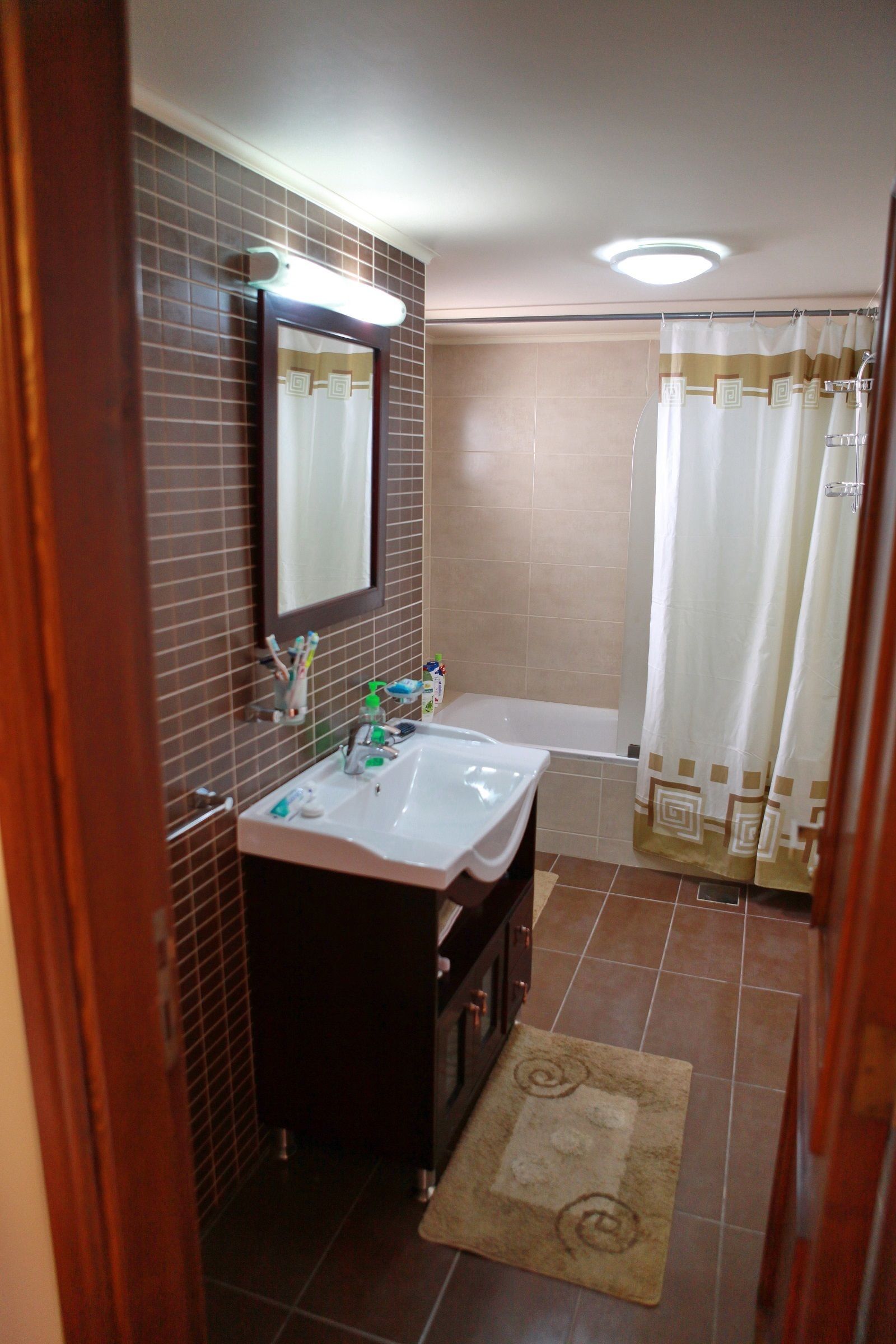 A bathroom with two sinks, a mirror, and a shower curtain.