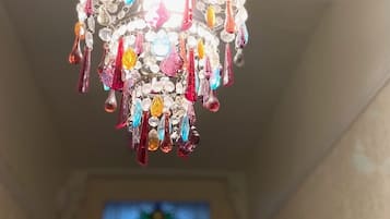 A chandelier with multiple colorful crystal pendants hanging from a metal frame.
