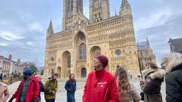 Una catedral histórica con arquitectura gótica, que presenta arcos apuntados y una alta torre con reloj.
