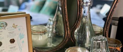 A table with tea bags, a glass jar, and a framed menu.