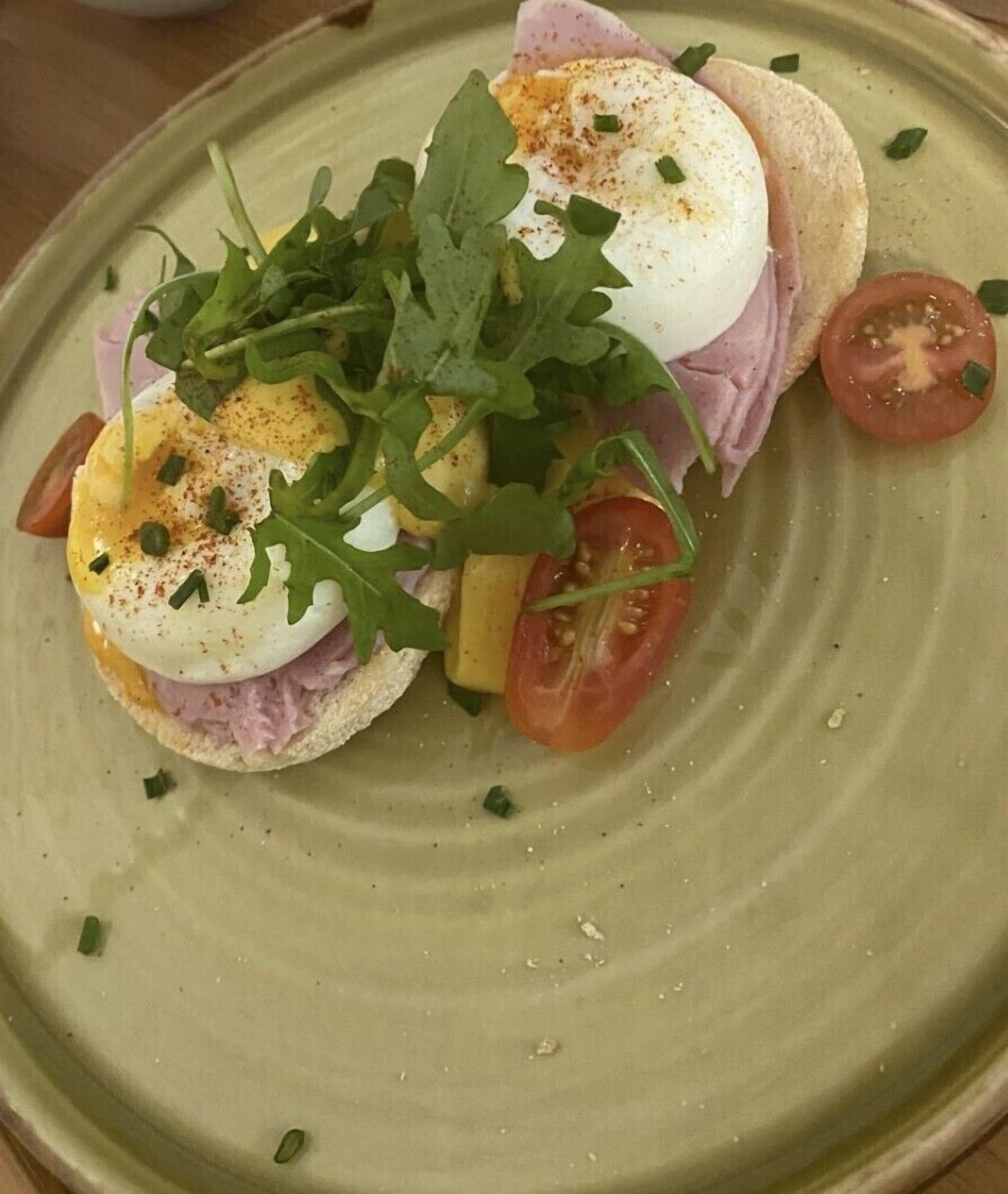 A plate with a sandwich, egg, and tomato slices.