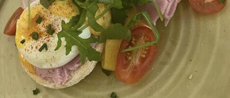 A plate with a sandwich, egg, and tomato slices.