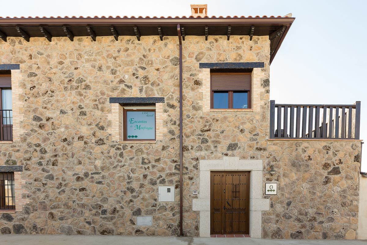 Un edificio de piedra con un letrero que dice "Calle Encounters de Montfrague".