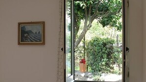 A room with a window, a picture on the wall, and a heater. - Gelsomino Rooms Ravello (Ravello)