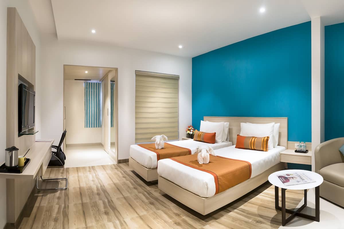 Une chambre d’hôtel avec un lit, un bureau, une chaise et une petite table.