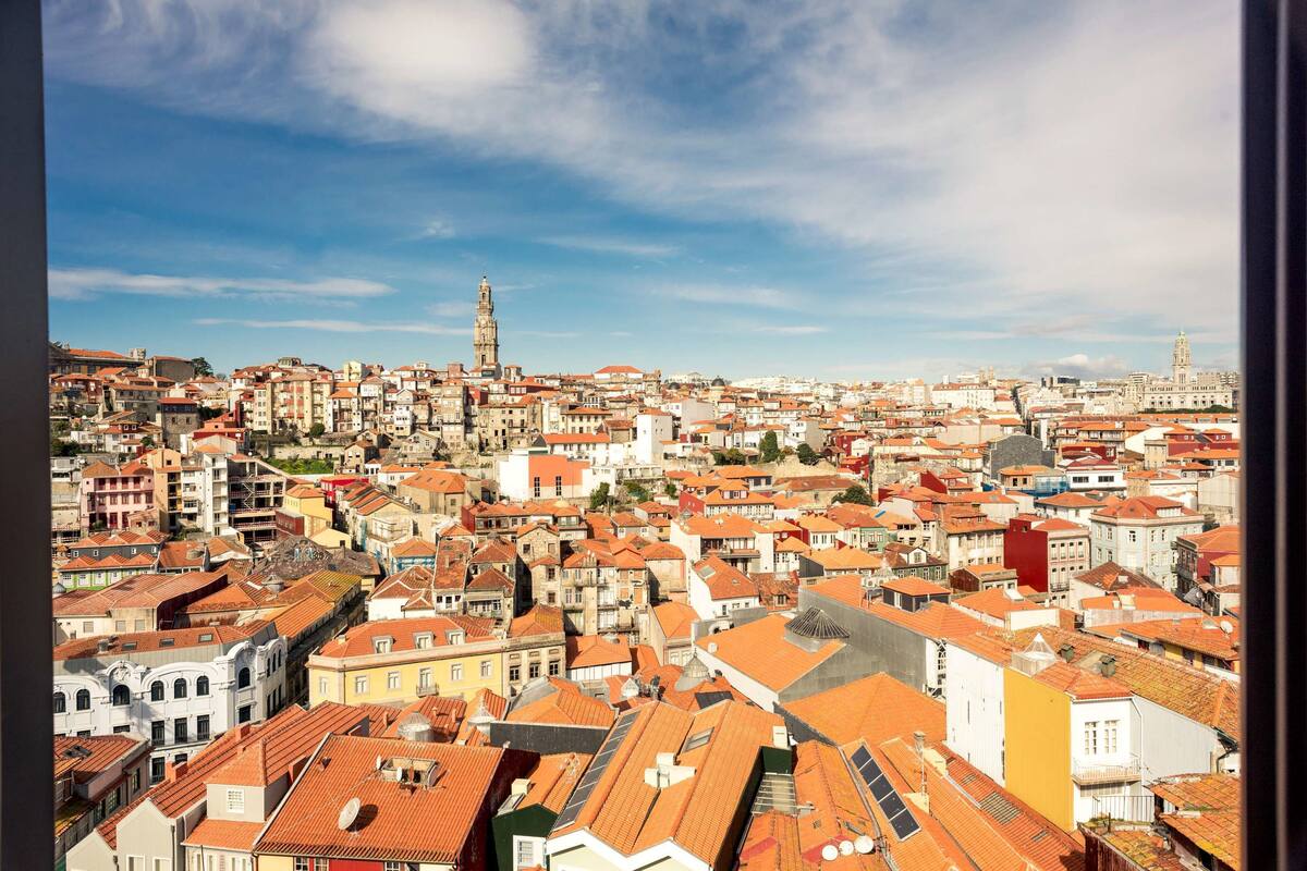 A panoramic view of a densely packed urban area with historic buildings and a prominent tower.