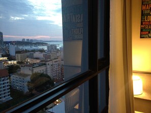 A cityscape view from a window with a lamp on the right.