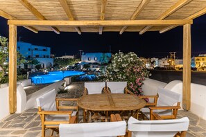 Un espacio de estar al aire libre cubierto con una piscina al fondo.
