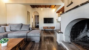 Ein modernes Wohnzimmer mit einer Eckcouch, einem Holztisch, einem Kamin und einem flachbildfernseher an der Wand.