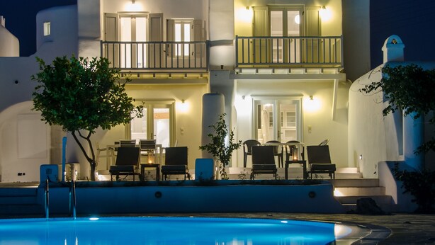 Ein zweistöckiges Gebäude mit einem Pool im Vordergrund.