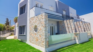 A modern two-story house with a stone facade and a balcony. - Nontas Hotel Apartaments (Chania)