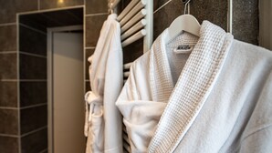 Ein Badezimmer mit Handtuchhalter und mehreren weißen Handtüchern.