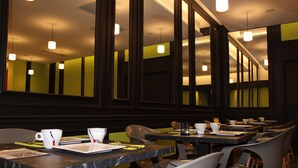 Ein Restaurant mit mehreren Tischen und Stühlen, jeder Tisch gedeckt mit einer Tasse, einem Teller und Besteck.