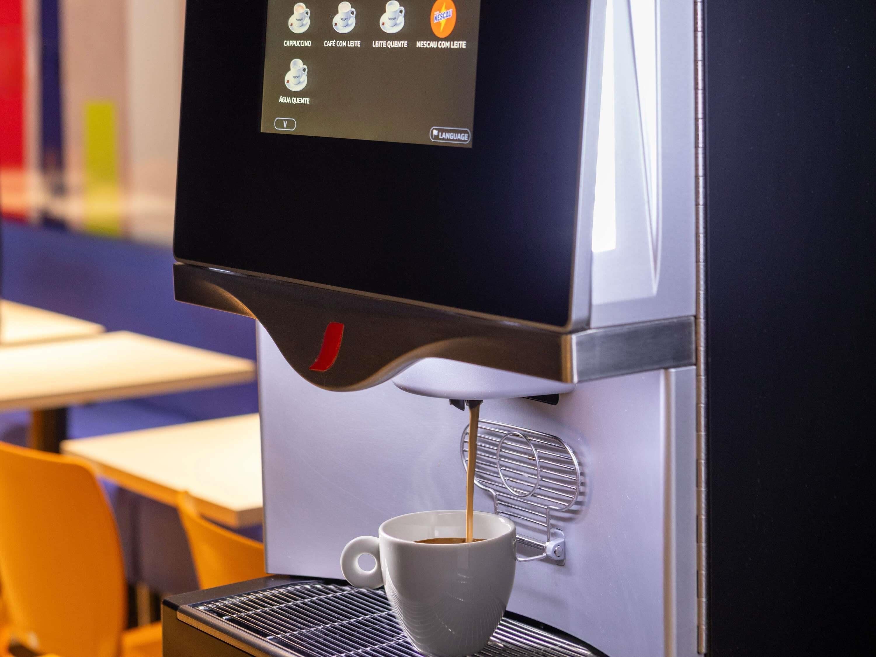 A coffee machine dispensing coffee into a cup.