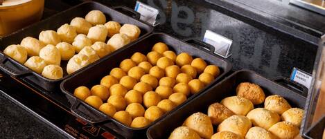 Un bufé con diversas opciones de panadería, incluyendo panes y pasteles.